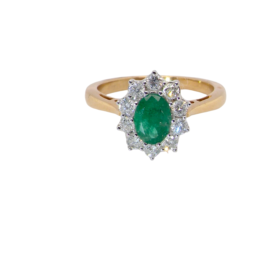 A fine traditional emerald and diamond cluster ring, featuring a vibrant oval-cut emerald to the centre measuring approximately 7 × 5 mm