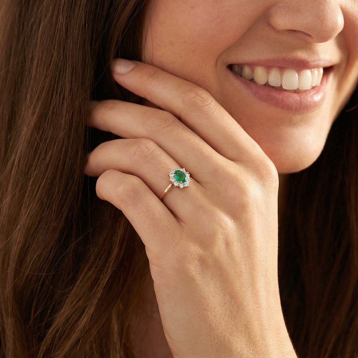 A fine traditional emerald and diamond cluster ring, featuring a vibrant oval-cut emerald to the centre measuring approximately 7 × 5 mm model