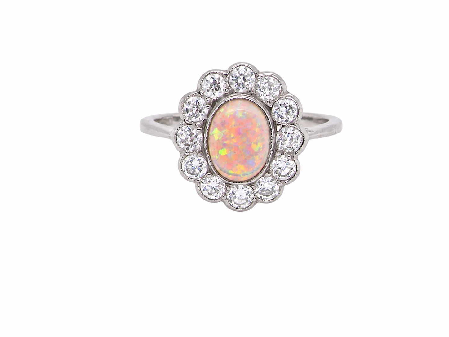 A fine vintage cluster ring. Features to the centre an oval shaped opal, with excellent play of colour, pink to one way, vibrant green to the other with flashes of electric blue also
