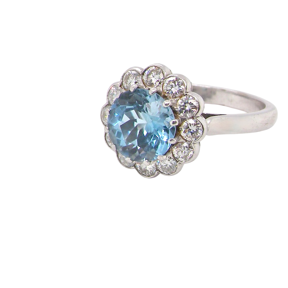 A fine vintage cluster ring centred with a deep blue aquamarine, measuring approximately 8mm 2 carats, securely claw set.