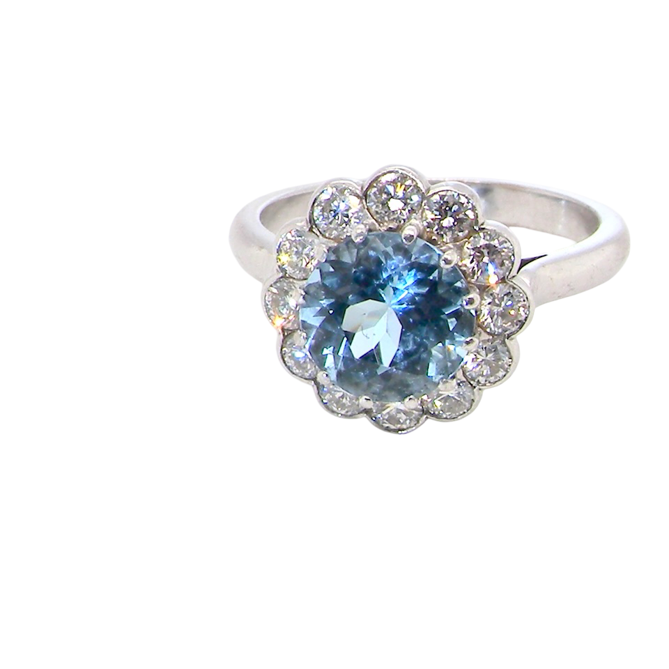 A fine vintage cluster ring centred with a deep blue aquamarine, measuring approximately 8mm