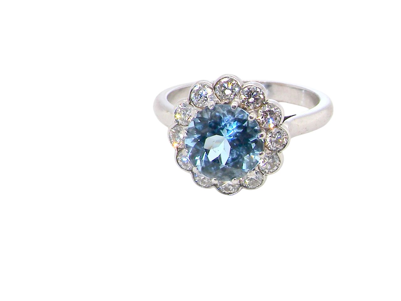 A fine vintage cluster ring centred with a deep blue aquamarine, measuring approximately 8mm