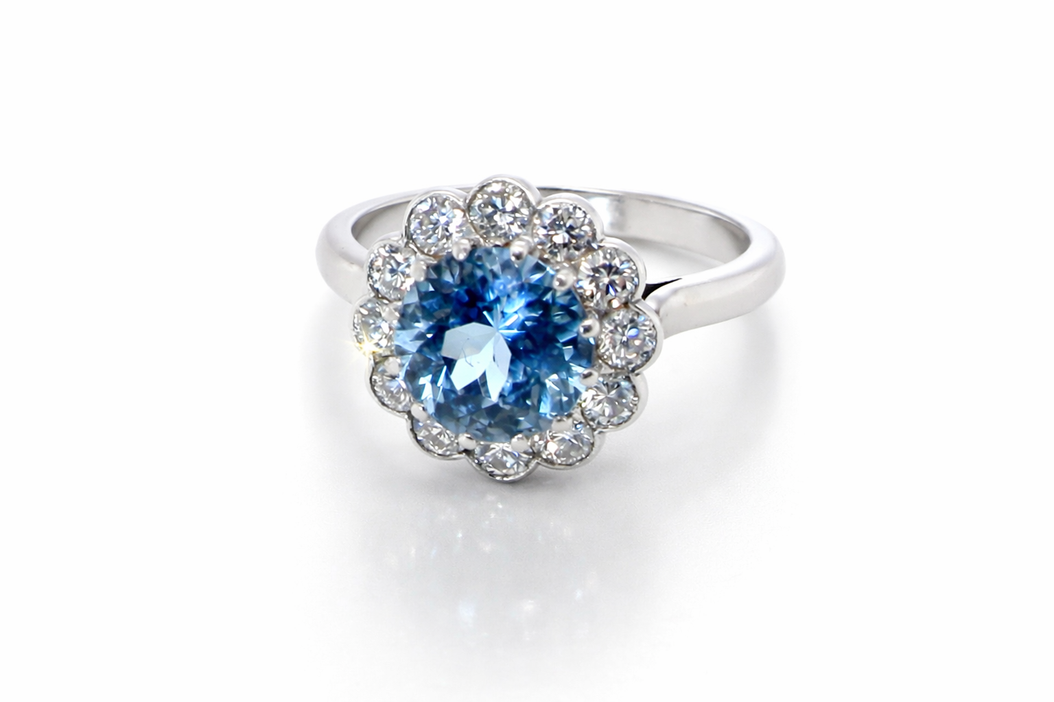 A fine vintage cluster ring centred with a deep blue aquamarine, measuring approximately 8mm and estimated at 2 carats, securely claw set.