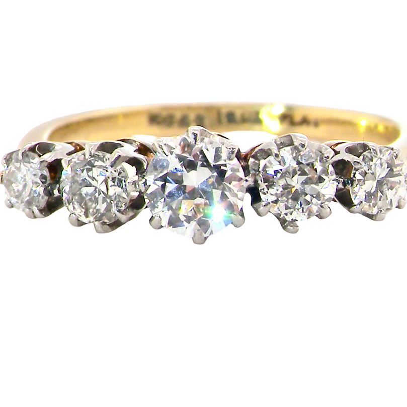 A five-stone diamond ring with a yellow gold band and silver-toned settings, featuring four round diamonds and a center oval diamond, shown on a plain white background.