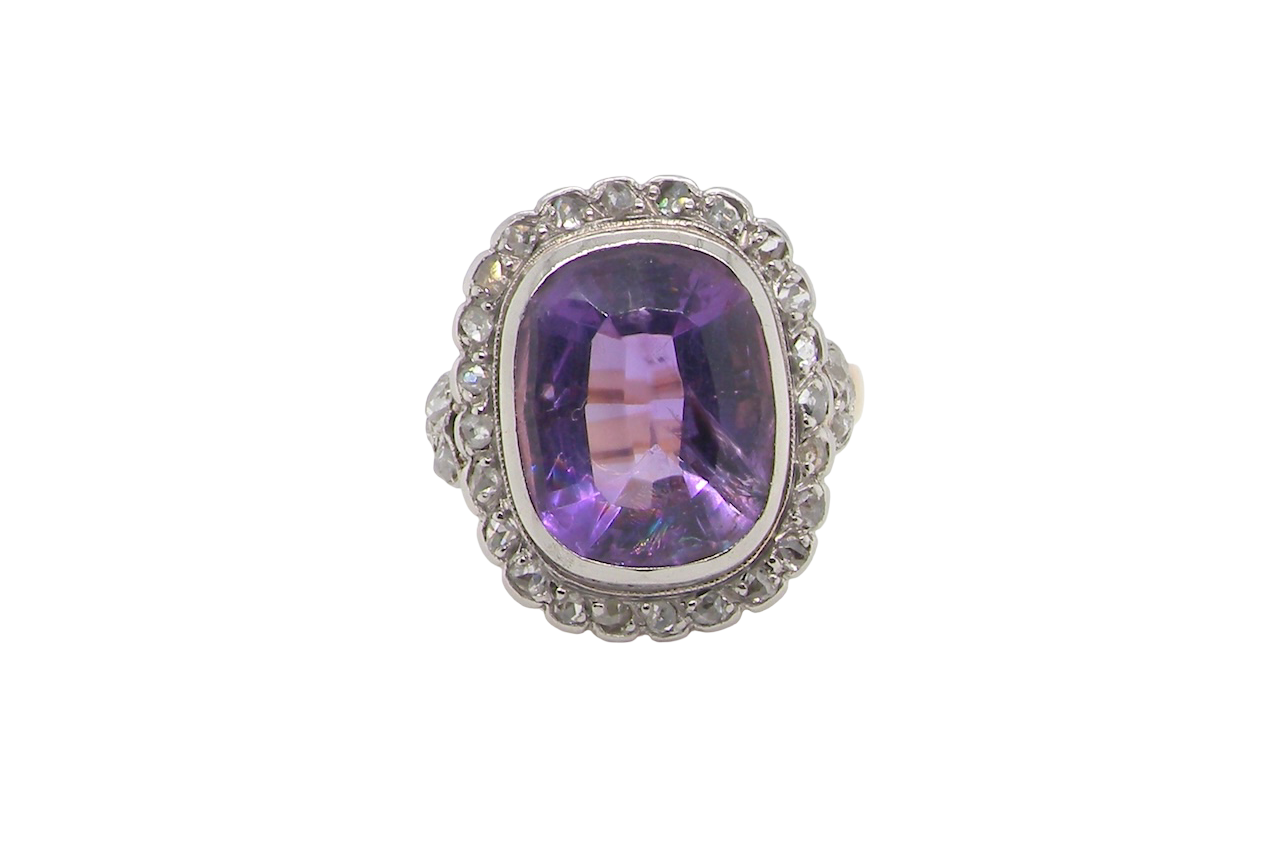 A fine vintage ring. Features to the centre a large cushion shaped amethyst, 13x10mm, rim setting.