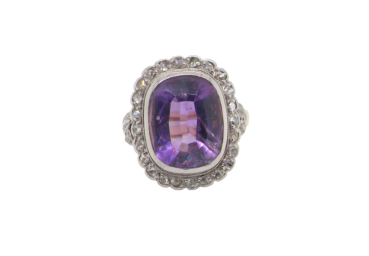 A fine vintage ring. Features to the centre a large cushion shaped amethyst, 13x10mm, rim setting.