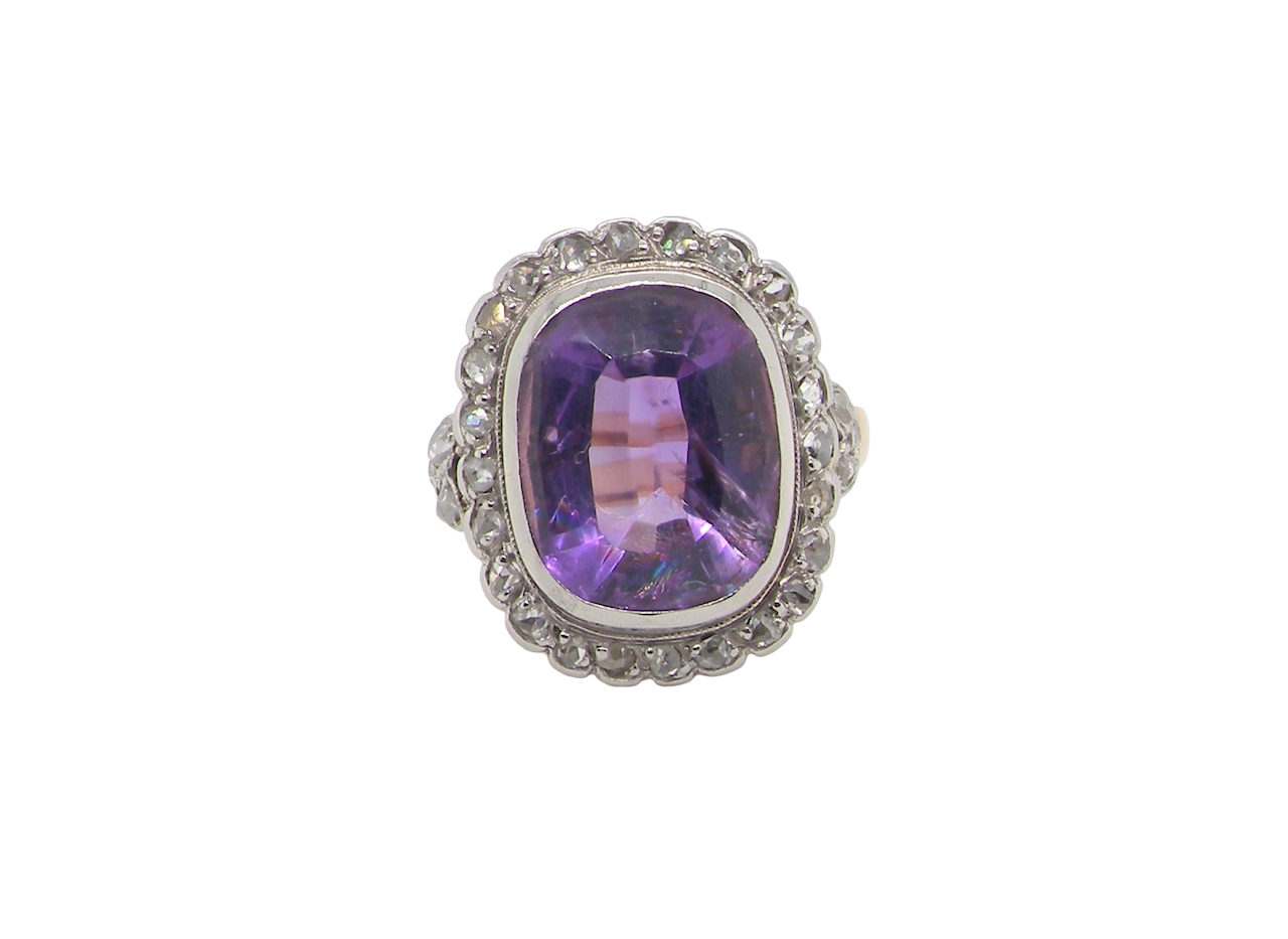 A fine vintage ring. Features to the centre a large cushion shaped amethyst, 13x10mm, rim setting.