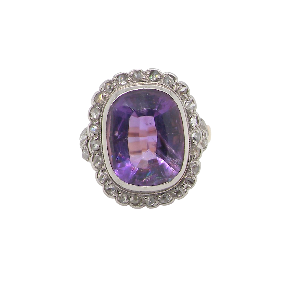 A fine vintage ring. Features to the centre a large cushion shaped amethyst, 13x10mm, rim setting.