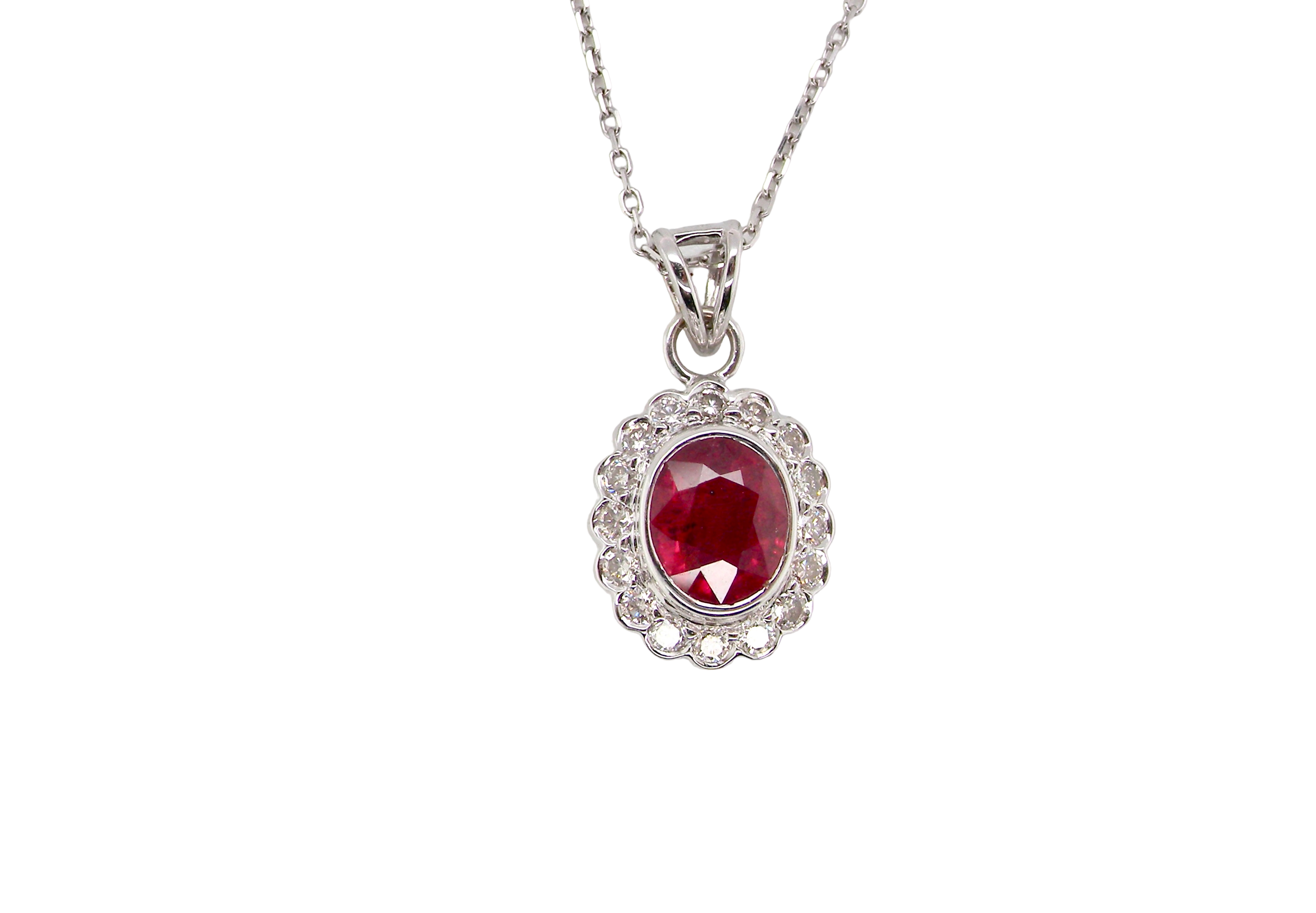 A fine white gold pendant that features to the centre an oval facet cut ruby, 8x6mm (est 1.25 carats) good deep red colour.
