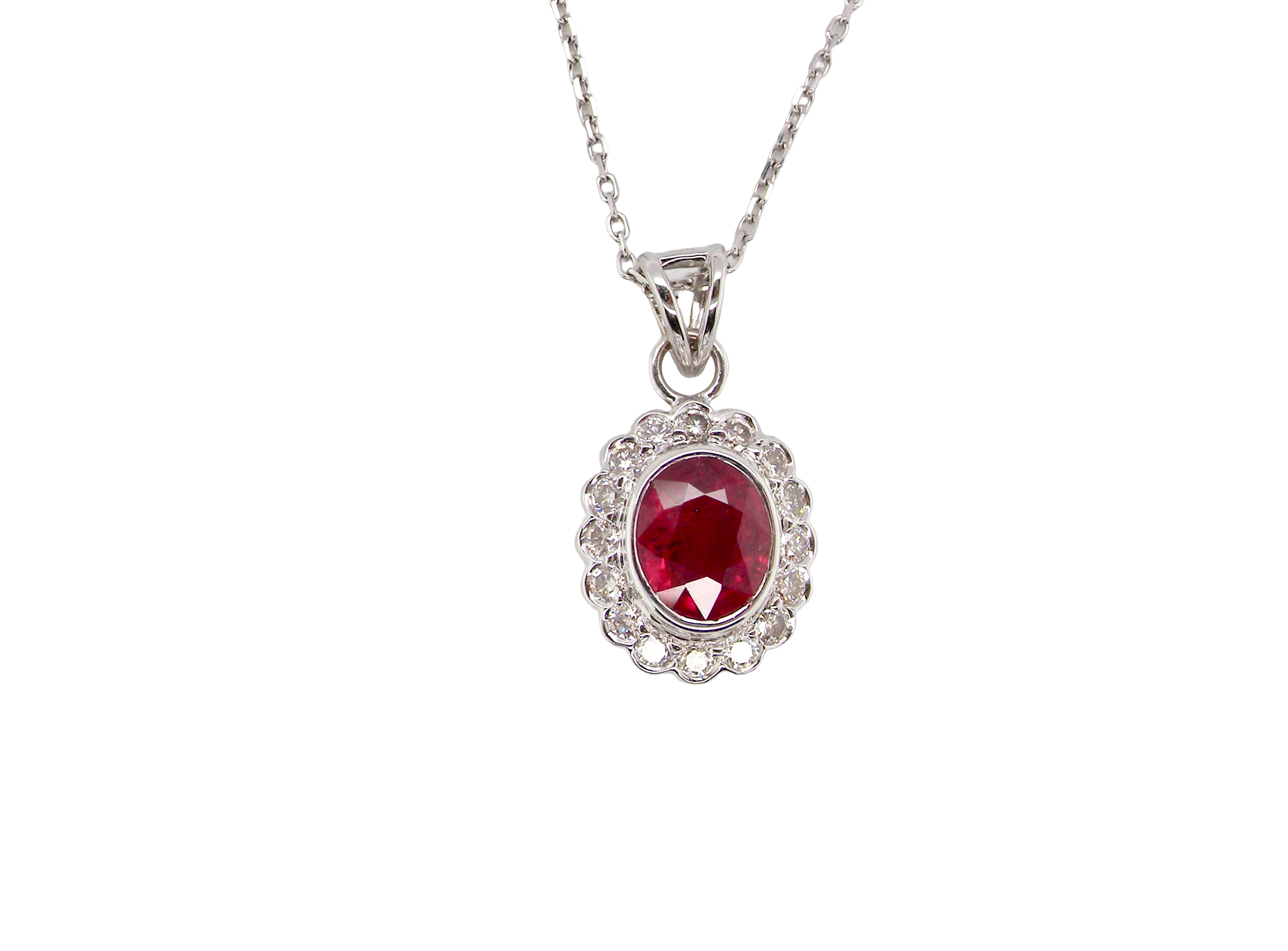 A fine white gold pendant that features to the centre an oval facet cut ruby, 8x6mm (est 1.25 carats) good deep red colour.