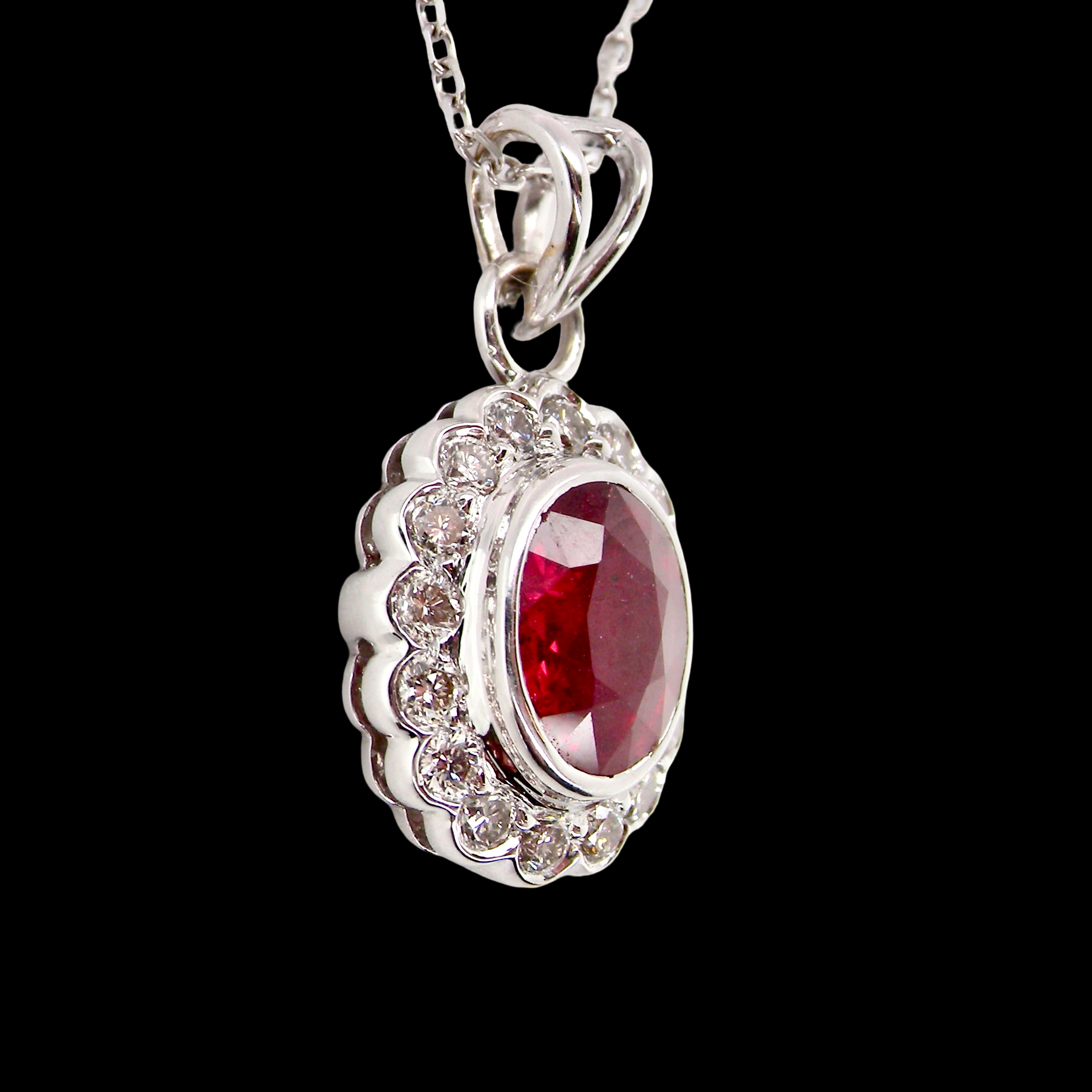 A fine white gold pendant that features to the centre an oval facet cut ruby, 8x6mm (est 1.25 carats) good deep red colour.
sidew