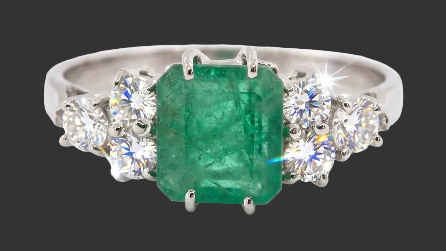 A fine white gold* ring that features a rectangular emerald centre stone, measures 6x6.5mm (est one carat),