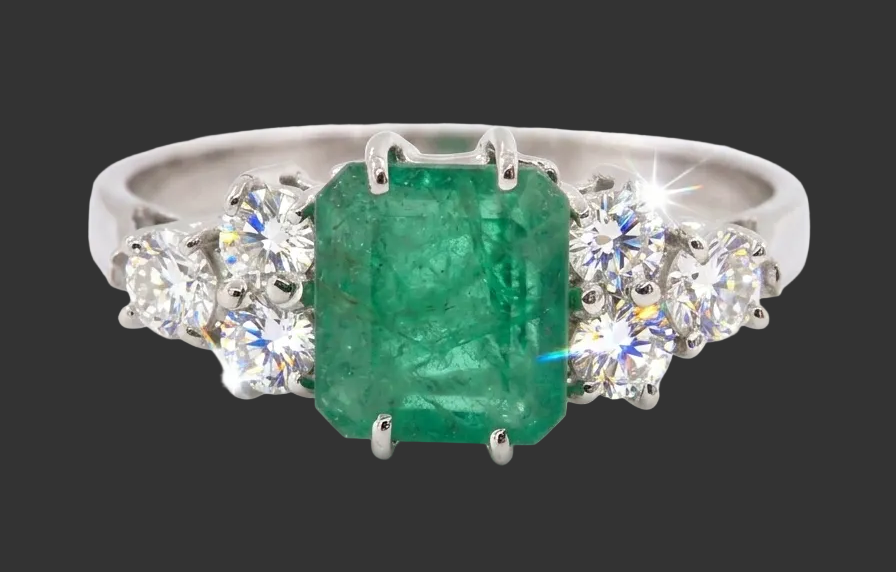 A fine white gold* ring that features a rectangular emerald centre stone, measures 6x6.5mm (est one carat),