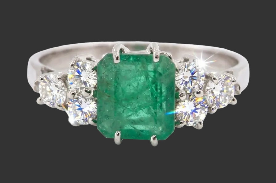 A fine white gold* ring that features a rectangular emerald centre stone, measures 6x6.5mm (est one carat),
