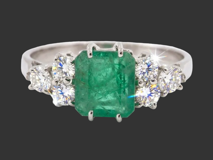 A fine white gold* ring that features a rectangular emerald centre stone, measures 6x6.5mm (est one carat),