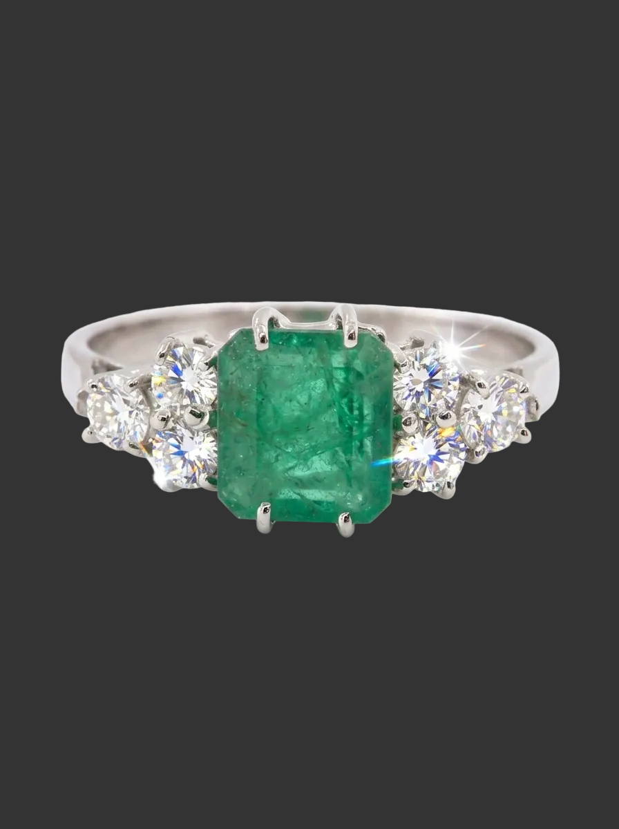 A fine white gold* ring that features a rectangular emerald centre stone, measures 6x6.5mm (est one carat),