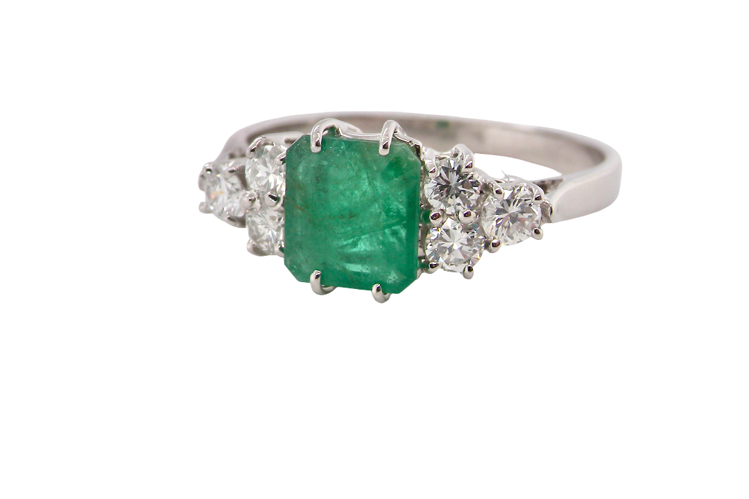 A fine white gold* ring that features a rectangular emerald centre stone, measures 6x6.5mm (est one carat), mid to dark green hue,