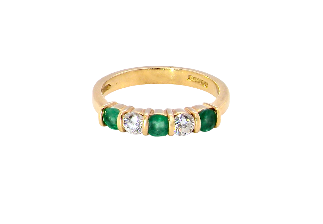 A five stone ring set with three emeralds, each 3mm diameter.
Between each two brilliant cut white diamonds, each 3.4mm (0.15 carats each est), colour i-j, clarity Si.