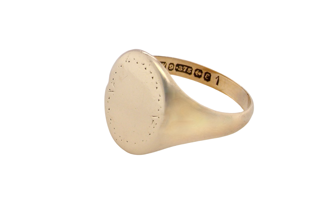 A gentlemans 9 carat gold signet ring. The head is oval with a pattern to the outer edges. 