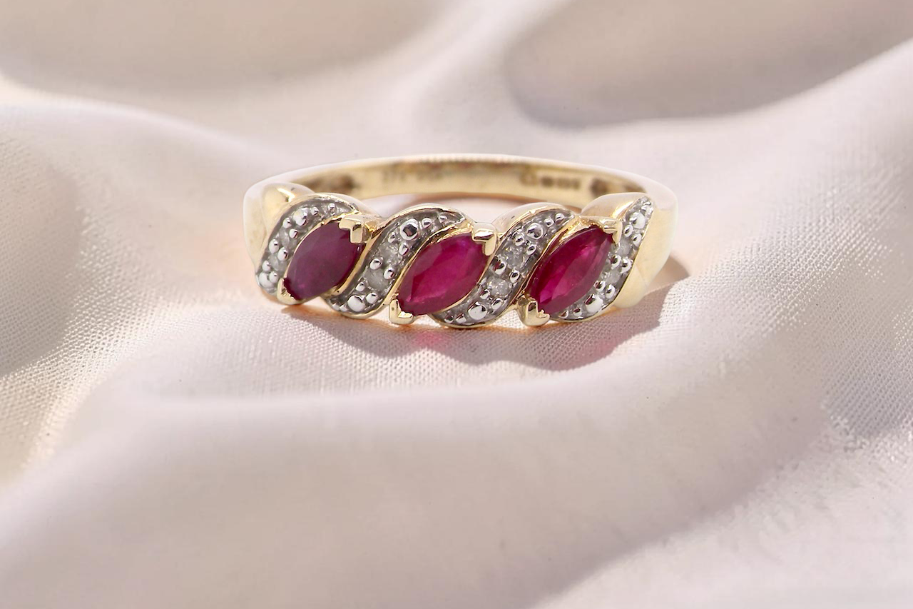 A gold dress ring. The three rubies are marquise cut, 5x3mm each, and set at an angle .