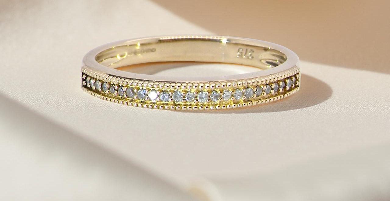 A half-hoop eternity ring set with approximately 24 white diamonds