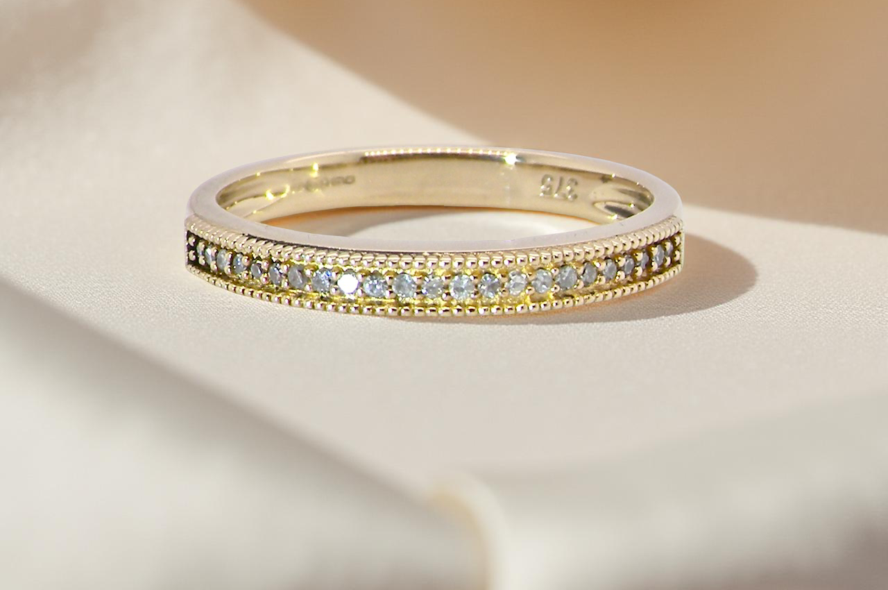 A half-hoop eternity ring set with approximately 24 white diamonds