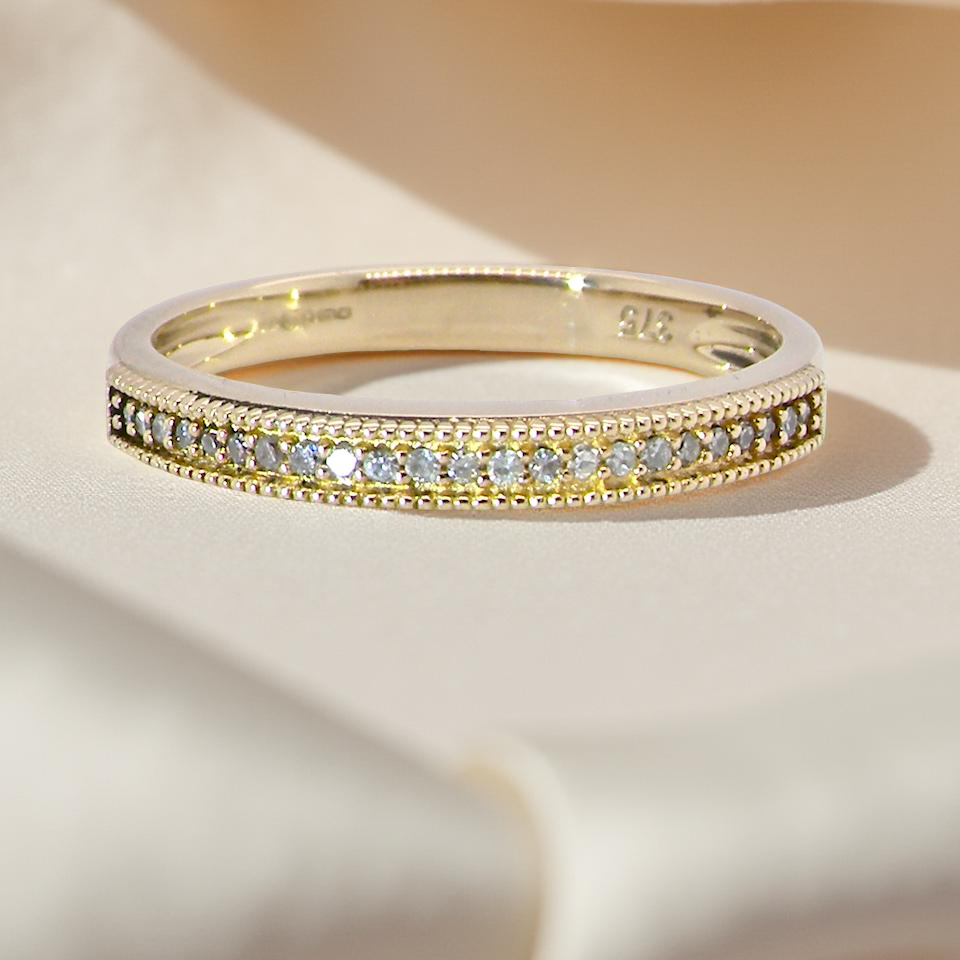A half-hoop eternity ring set with approximately 24 white diamonds