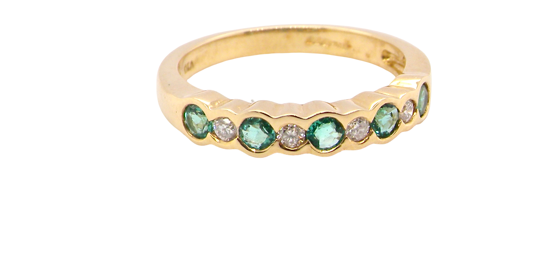 A half hoop eternity ring. Set with five round emeralds, each 3mm (0.10 carats) and set with an alternate brilliant cut white diamond,