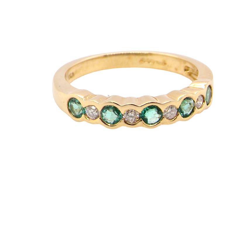 A half hoop eternity ring. Set with five round emeralds, each 3mm (0.10 carats) and set with an alternate brilliant cut white diamond,