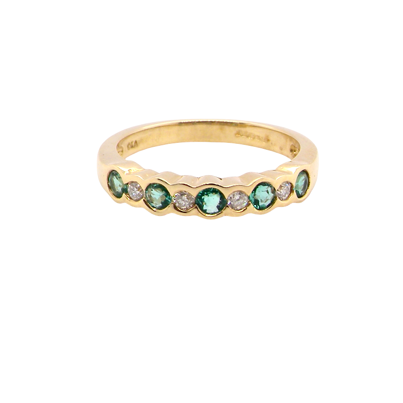 A half hoop eternity ring. Set with five round emeralds, each 3mm (0.10 carats) and set with an alternate brilliant cut white diamond, 2.4mm each (total 0.20 carats)
