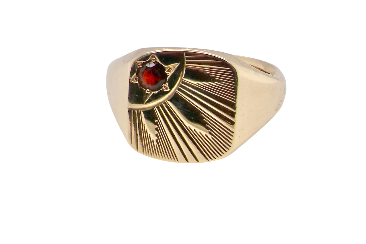 Gold ring with a red gemstone on a white background