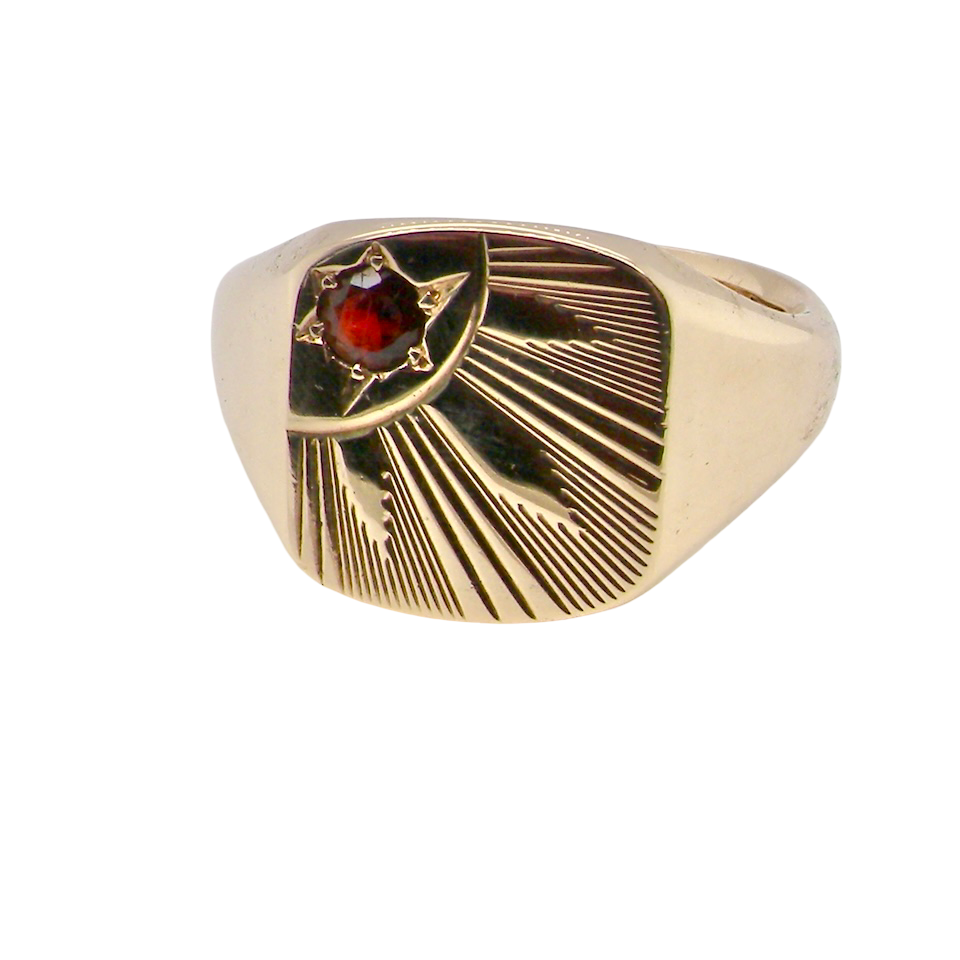 Gold ring with a red gemstone on a white background