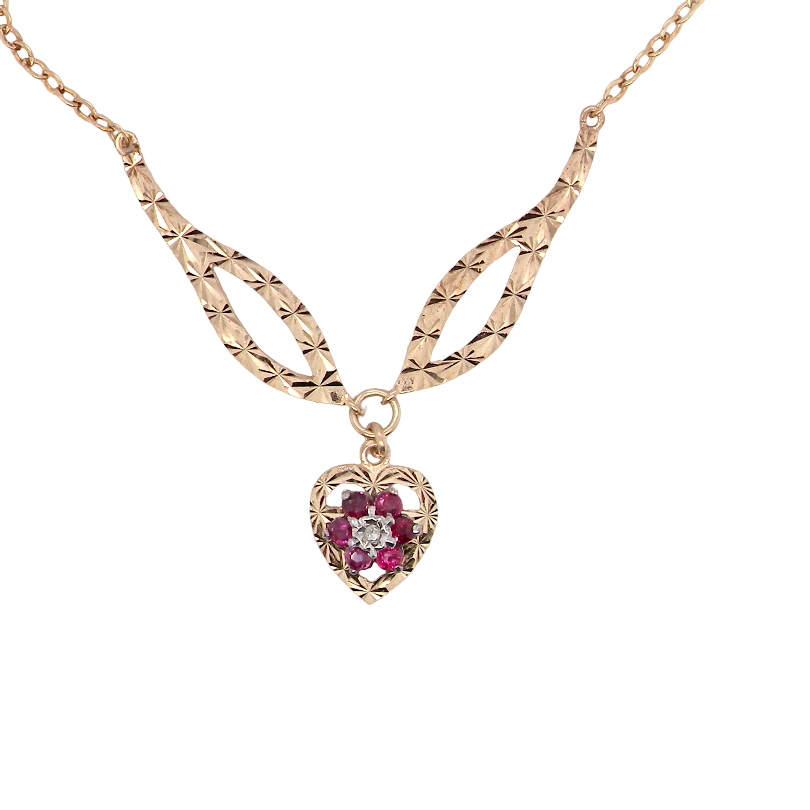A late 1970s pendant/necklace. Features a heart shaped pendant that has a cluster set to its centre. Six small rubies 2.3mm each surround a diamond. Diamond cut outer rim.