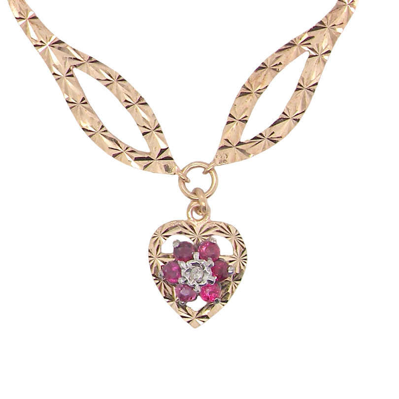 A late 1970s pendant/necklace. Features a heart shaped pendant that has a cluster set to its centre. Six small rubies 2.3mm each surround an illusion set diamond.