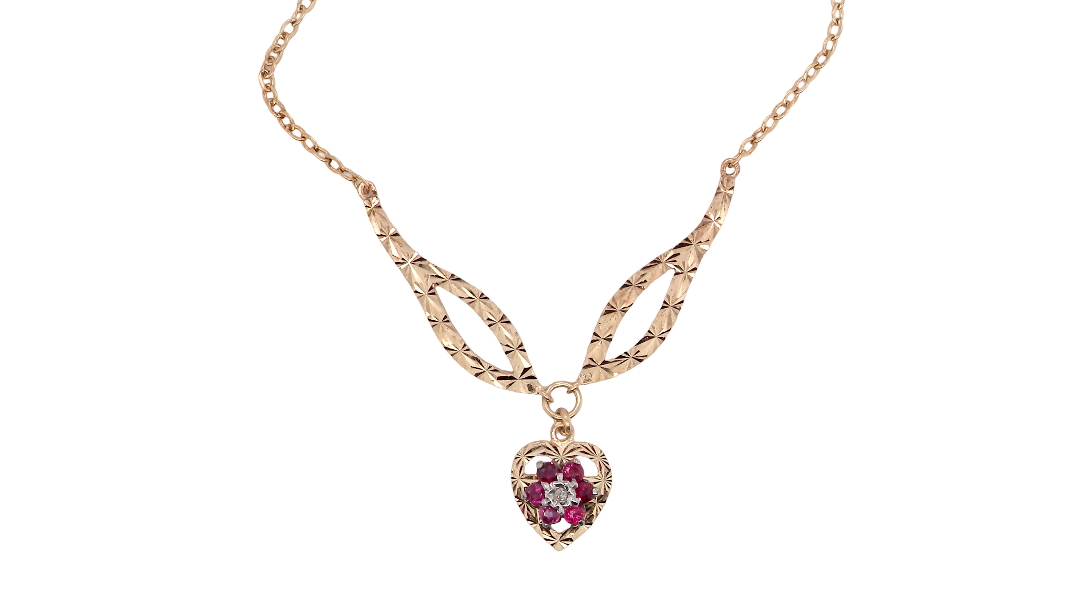 A late 1970s pendant/necklace. Features a heart shaped pendant that has a cluster set to its centre. Six small rubies 2.3mm each surround an illusion set diamond. Diamond cut outer rim.