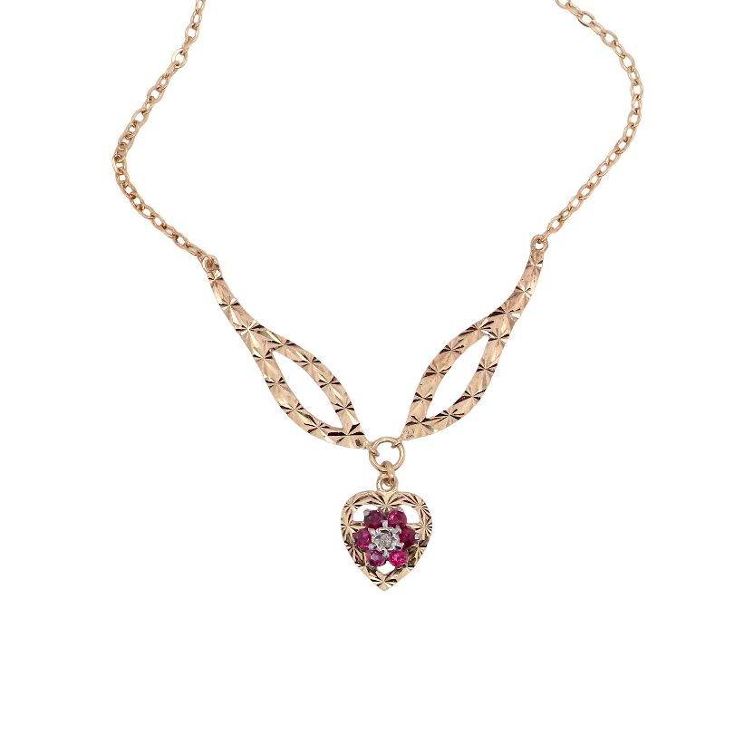 A late 1970s pendant/necklace. Features a heart shaped pendant that has a cluster set to its centre. Six small rubies 2.3mm each surround an illusion set diamond. Diamond cut outer rim.