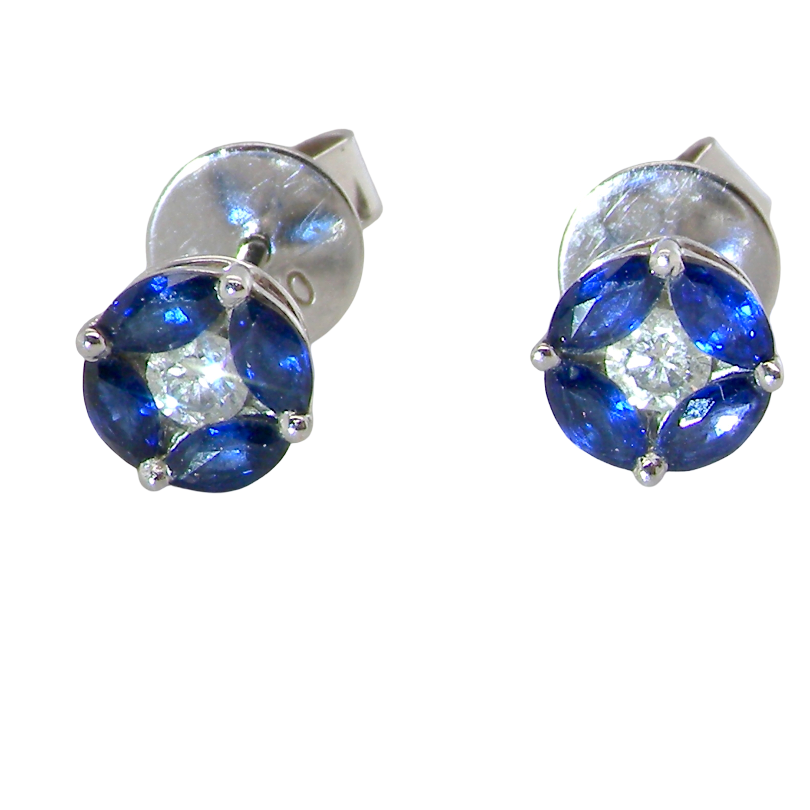 A pair of round stud earrings featuring deep blue gemstones in a four-petal arrangement with a clear center stone, set in silver-toned metal on a plain white background.