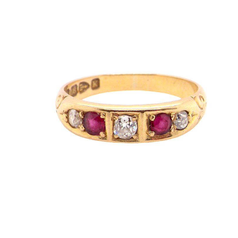 A vintage yellow gold ring featuring a row of round-cut pinkish-red rubies and clear diamonds, photographed on a solid white background.