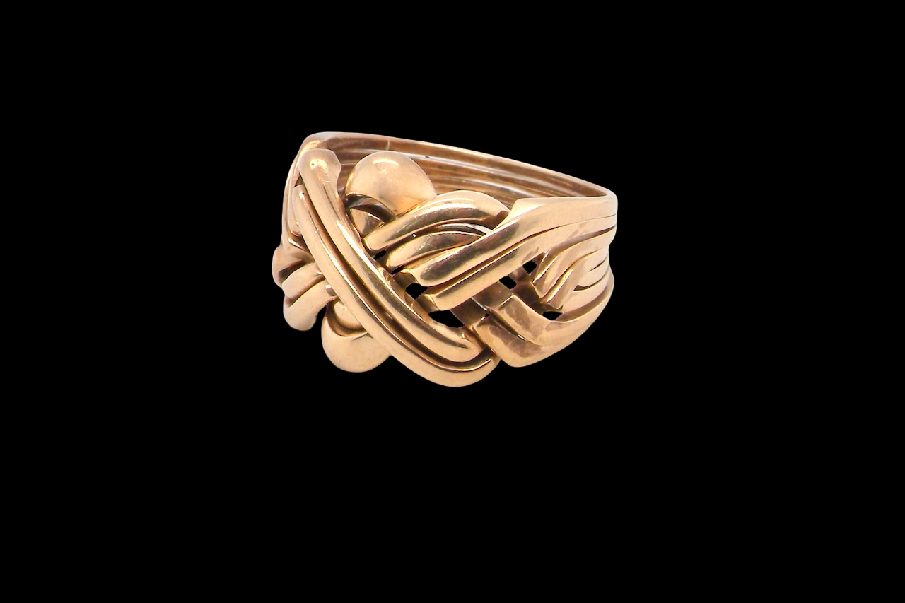 Gold ring with a unique design on a black background