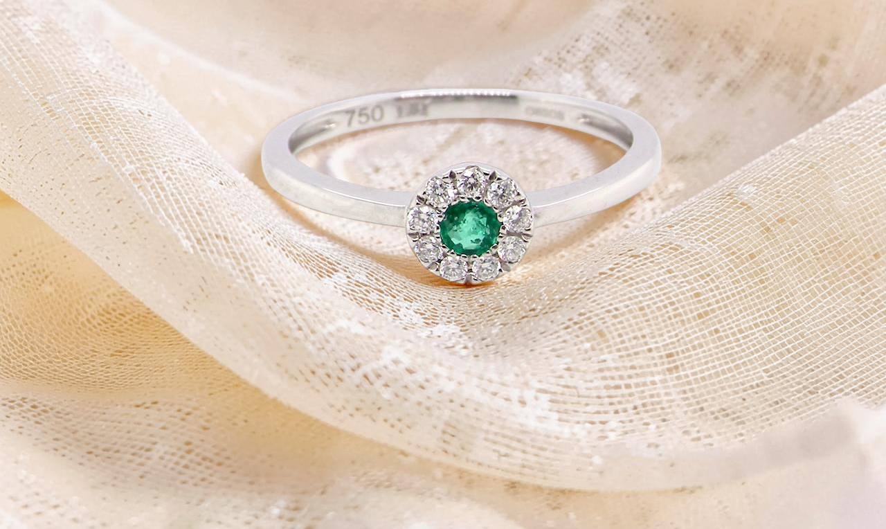 A mini cluster fashioned in 18 carat white gold. The round emerald measures 2.7mm 