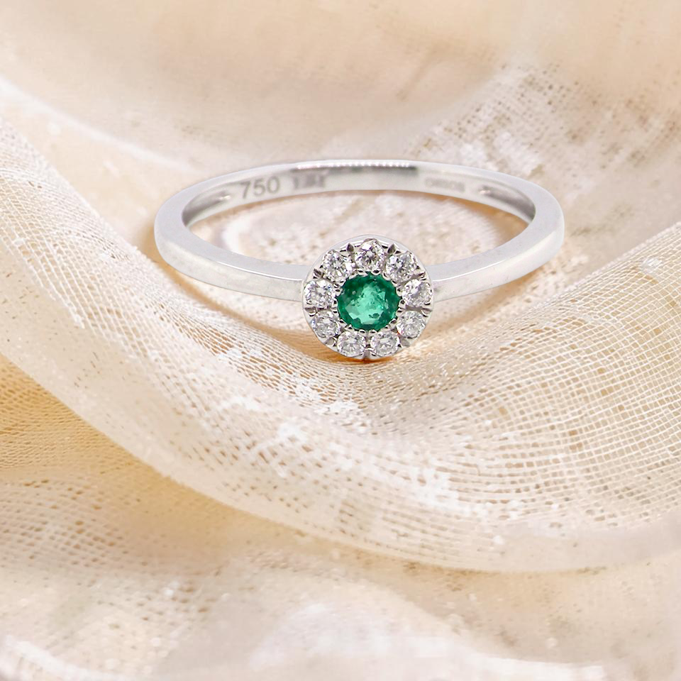 A mini cluster fashioned in 18 carat white gold. The round emerald measures 2.7mm 