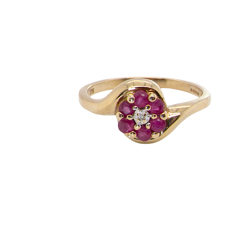 A modern 9 carat gold cluster ring. At the centre a small diamond, this complimented by an outer halo of six 2.4mm rubies (each 0.05 carats)