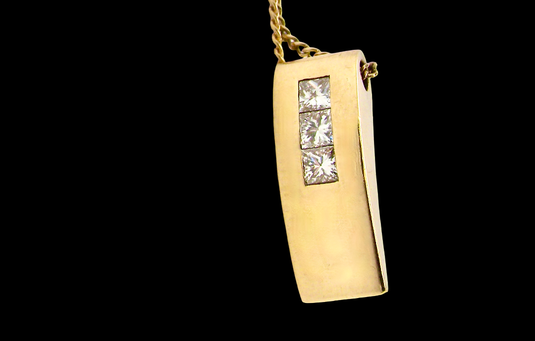 side view A modern block style pendant. Measures 17x6.3mm. Set with three princess cut white diamonds, close set, each measures 2.75-2.85mm (total est 0.40 carats). 