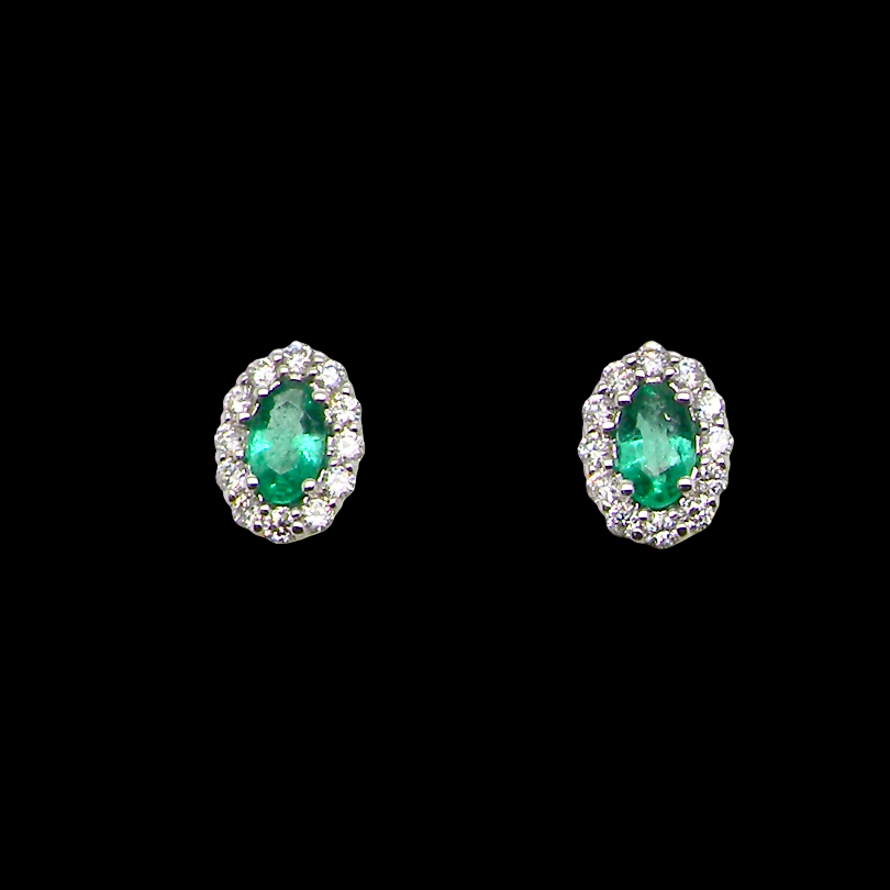 A pair of oval stud earrings featuring marquise-cut green emeralds surrounded by small clear stones in a silver-toned setting, presented on a solid black background.