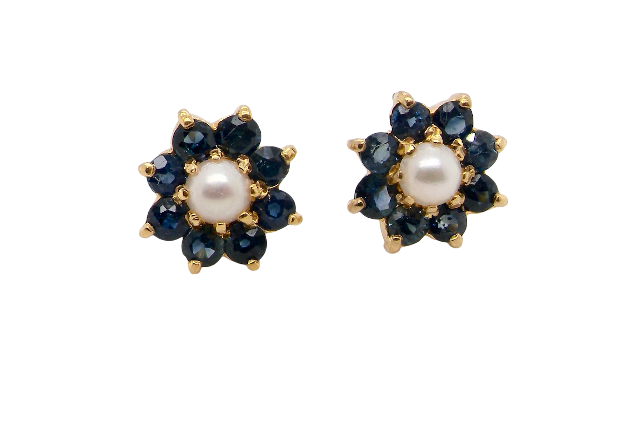 A pair of 9 carat gold cluster earrings. The centre set with a cultured pearl 4mm diameter. Surrounded by eight round sapphires,