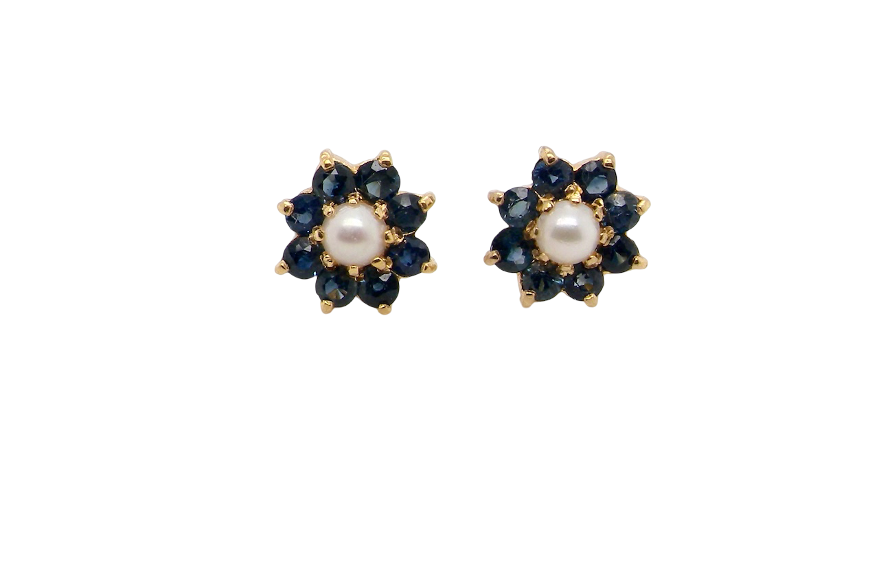 A pair of 9 carat gold cluster earrings. The centre set with a cultured pearl 4mm diameter. Surrounded by eight round sapphires, each 3.3mm.