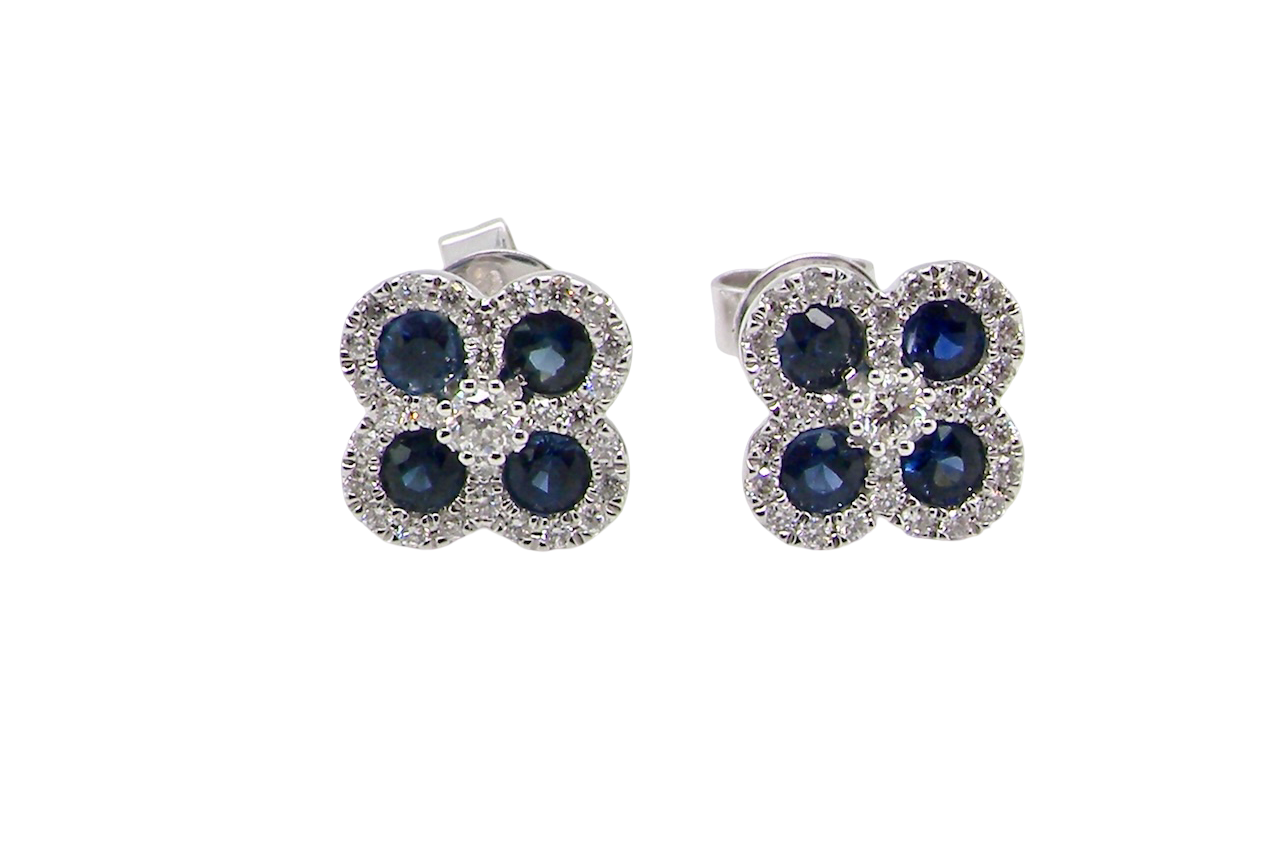 Pair of flower-shaped earrings with blue stones on a white background