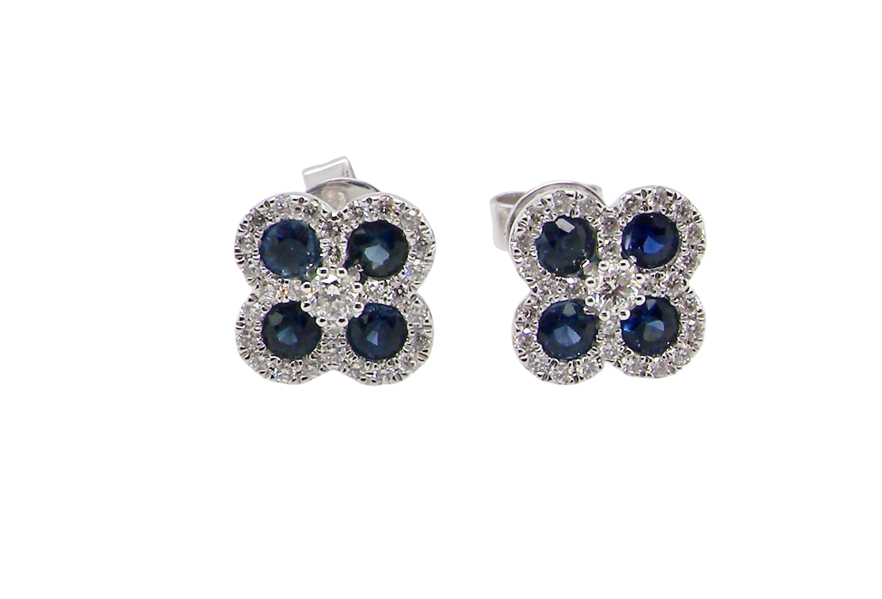 Pair of flower-shaped earrings with blue stones on a white background