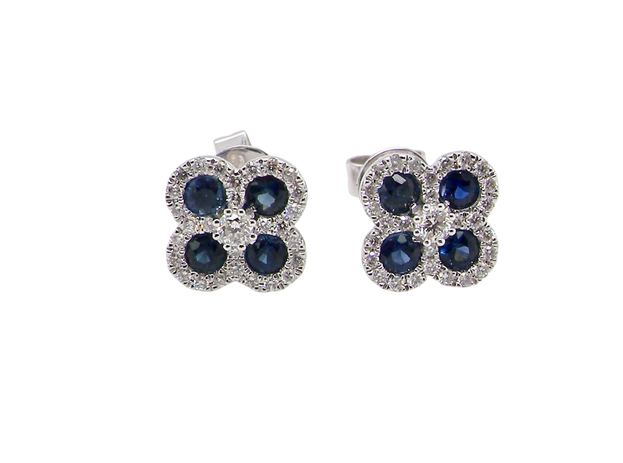 Pair of flower-shaped earrings with blue stones on a white background