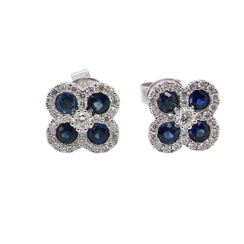 Pair of flower-shaped earrings with blue stones on a white background